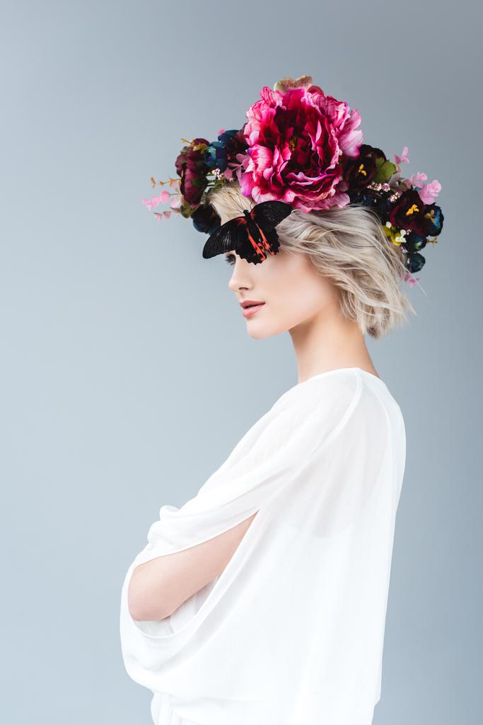 fille élégante posant en chemisier blanc et couronne florale avec papillon, isolé sur gris
 - Photo, image