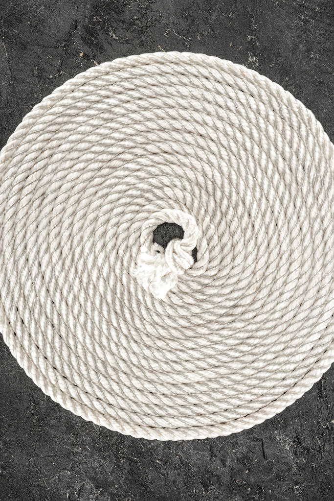 pohled shora bílé námořní lana uspořádaných v kruhu na temné konkrétní stolní - Fotografie, Obrázek