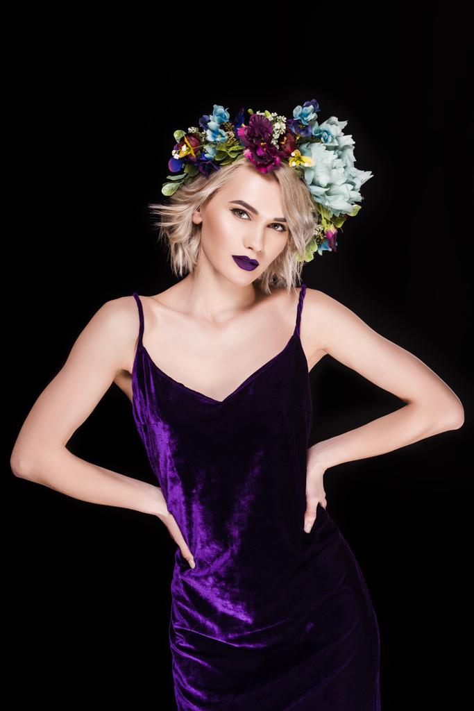 blonde girl posing in purple dress and floral wreath, isolated on black - Photo, Image