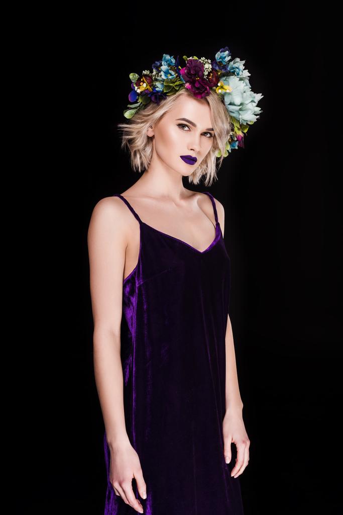 beautiful blonde girl posing in purple dress and flower wreath, isolated on black - Photo, Image