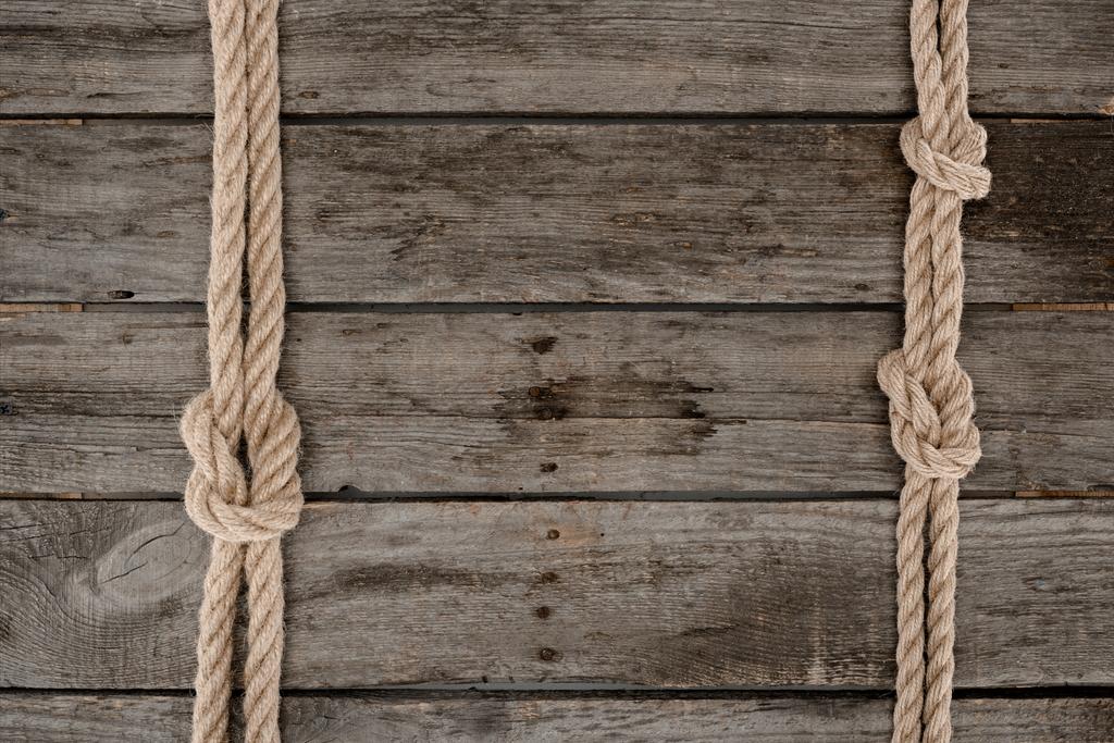 vlakke leggen met mariene touwen met knopen op grunge houten tafelblad - Foto, afbeelding