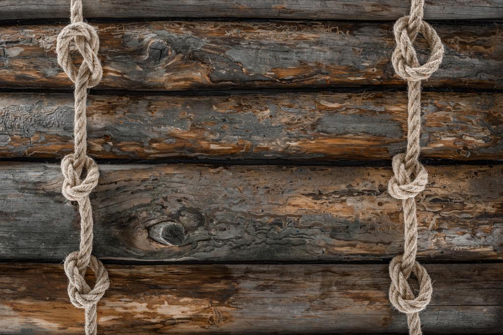 vlakke leggen met gearrangeerde mariene touwen met knopen op grunge houten tafelblad - Foto, afbeelding