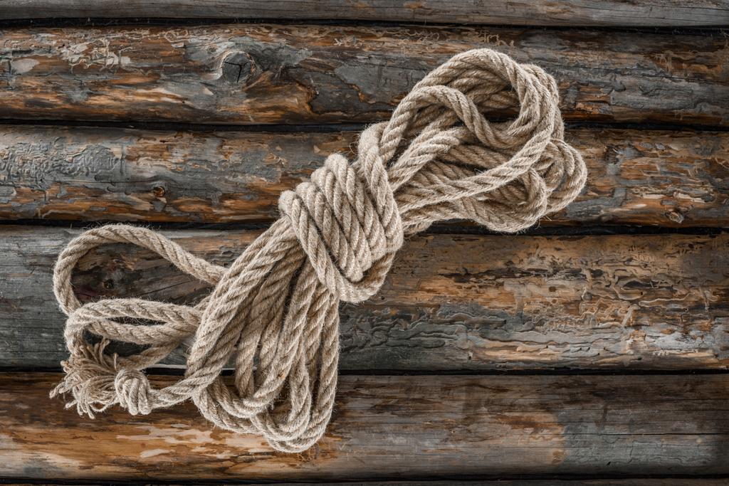 bovenaanzicht van gebonden nautische touw op grunge houten oppervlak - Foto, afbeelding