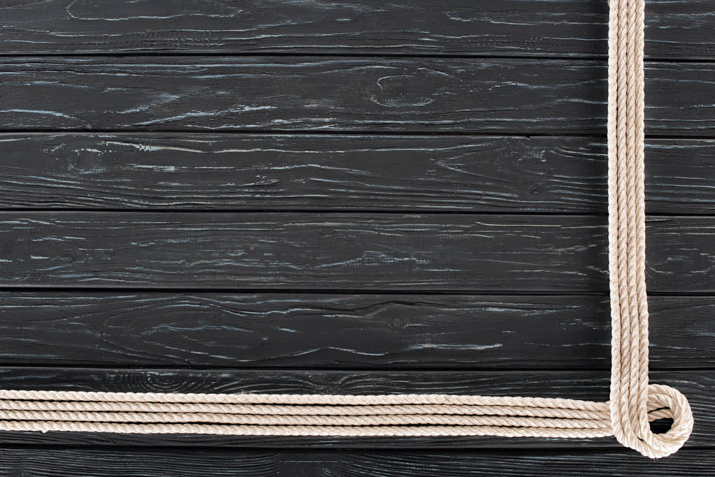 το Top view τοποθετημένα λευκό θαλάσσια σχοινιά σε σκούρα ξύλινα επιτραπέζια - Φωτογραφία, εικόνα