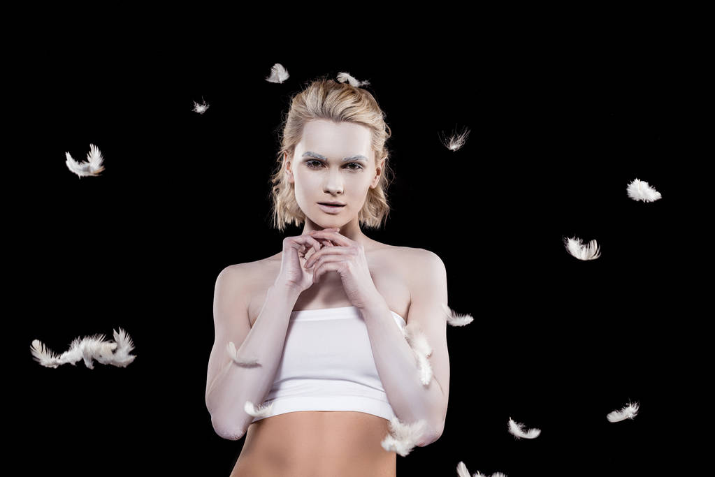 blonde girl with white makeup, isolated on black with feathers - Photo, Image