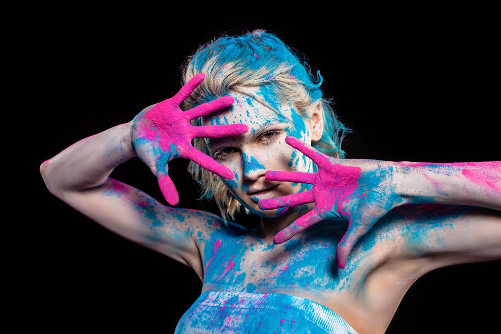 El hareketi ve pembe ve mavi holi toz, siyahta izole poz çekici kız - Fotoğraf, Görsel