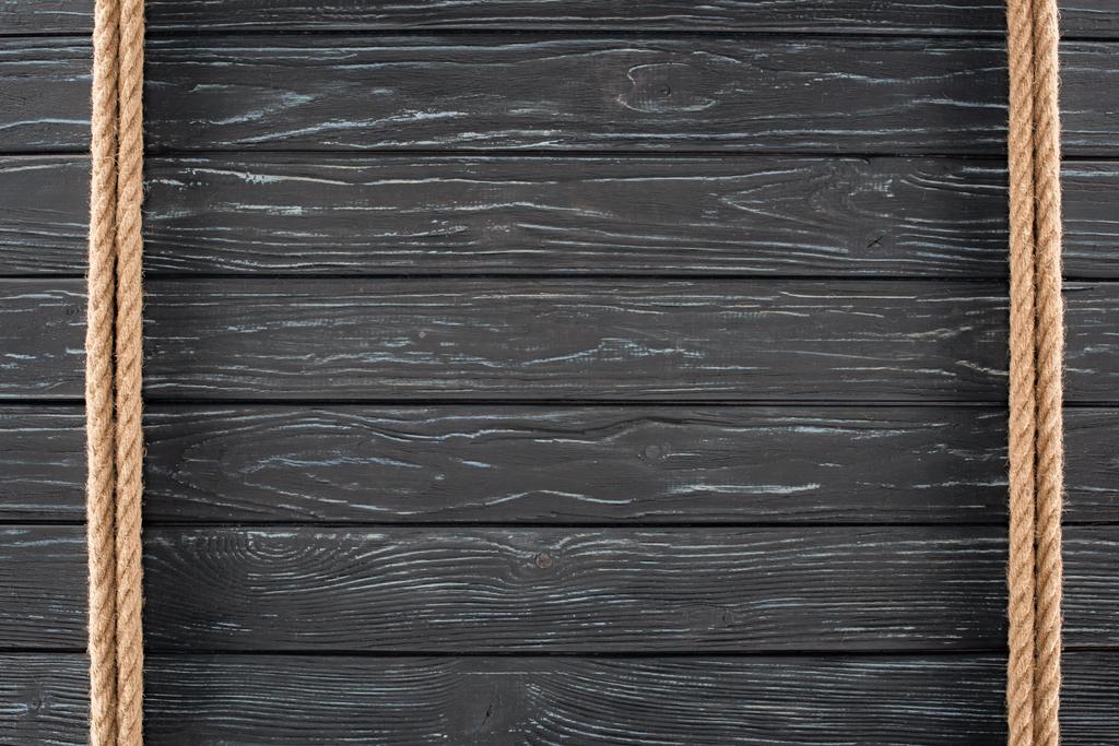 bovenaanzicht van bruin touwen op donkere houten oppervlak - Foto, afbeelding