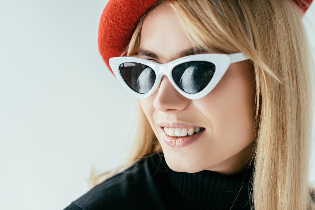 Kırmızı bere ve güneş gözlüğü gri izole çekici genç kadın - Fotoğraf, Görsel