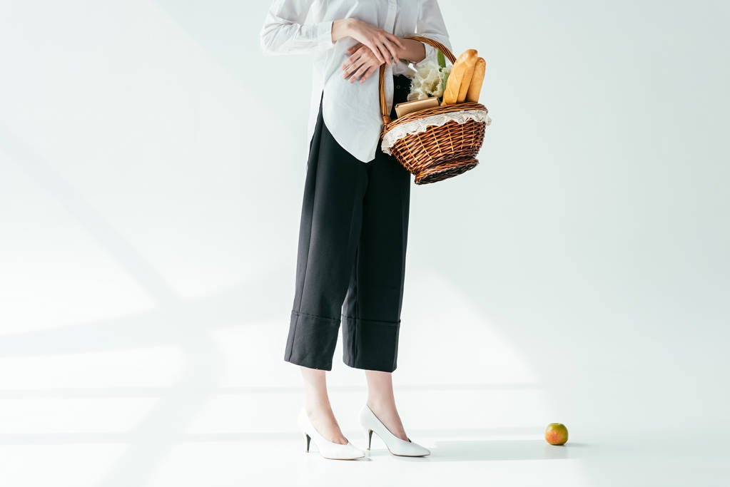 Vergrote weergave van de modieuze vrouw met mand met brood en bloemen - Foto, afbeelding