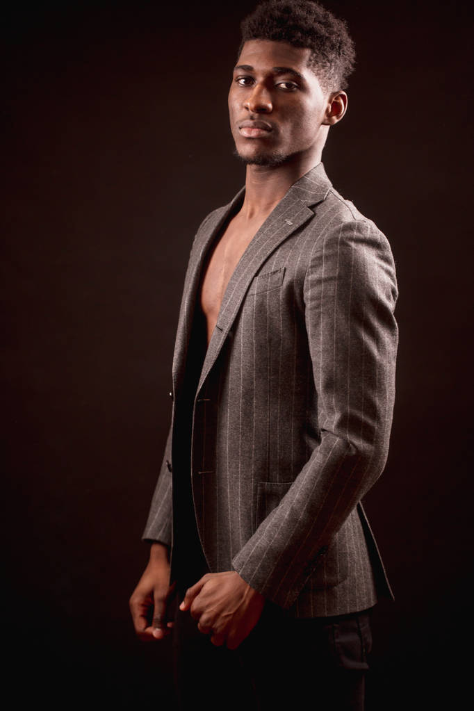 schöner muskulöser Afro-junger Mann in klassischer Jacke auf nacktem Oberkörper - Foto, Bild