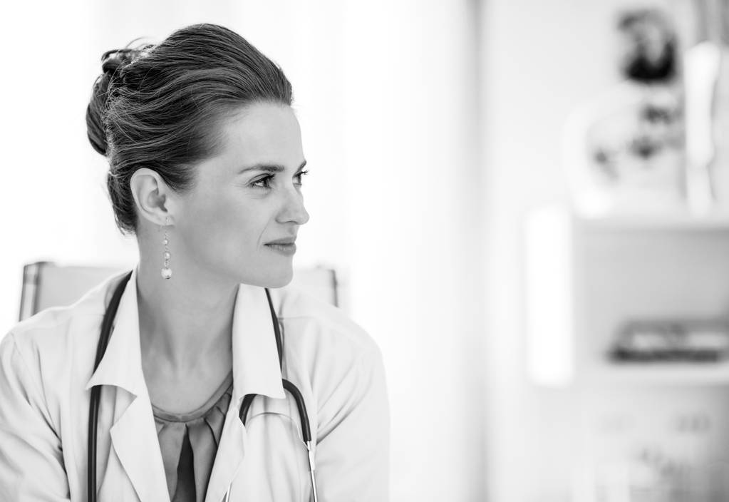 Современное здравоохранение. Портрет женщины-врача, сидящей за столом в офисе
 - Фото, изображение