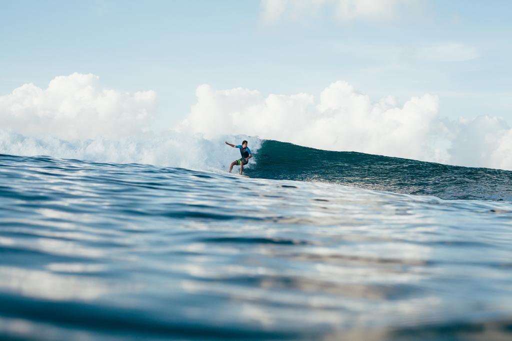 jonge atletische sportman in wetsuit surfen op zonnige dag - Foto, afbeelding
