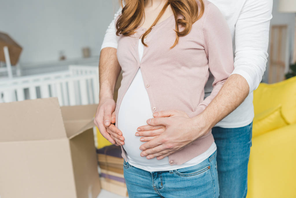 mid section of man embracing pregnant wife at new home - Photo, Image