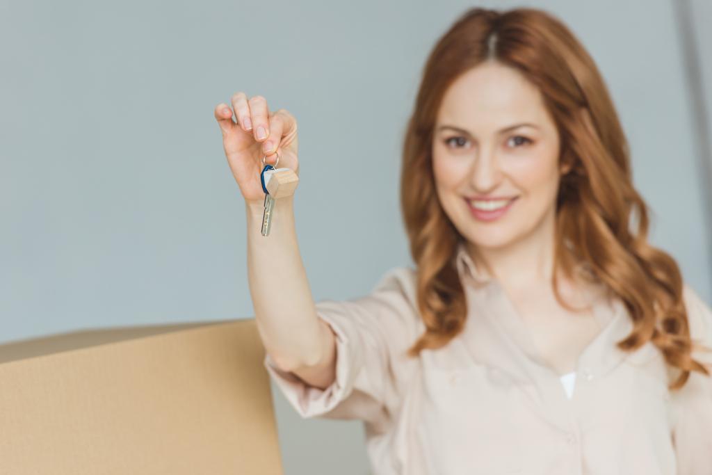 Áthelyezés koncepció mutatja a kulcsok-ból új lakás a kezében, mosolygós nő - Fotó, kép