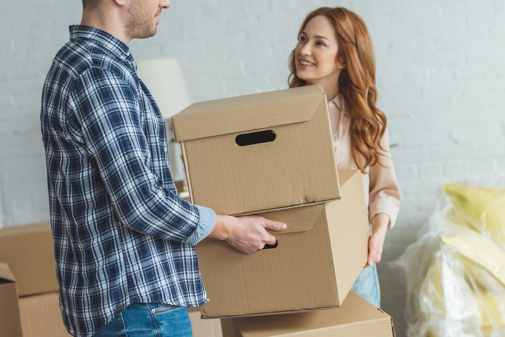 částečný pohled usmívající se žena a manžel stmelování kartonových krabic na nový byt, přesun domů concept - Fotografie, Obrázek
