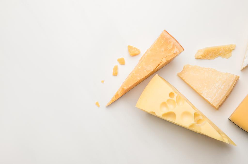 Vista superior de varios tipos de queso en blanco
  - Foto, Imagen