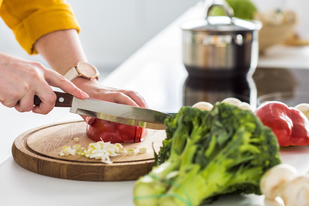 обрезанный образ женщины, режущей перец на кухне
 - Фото, изображение
