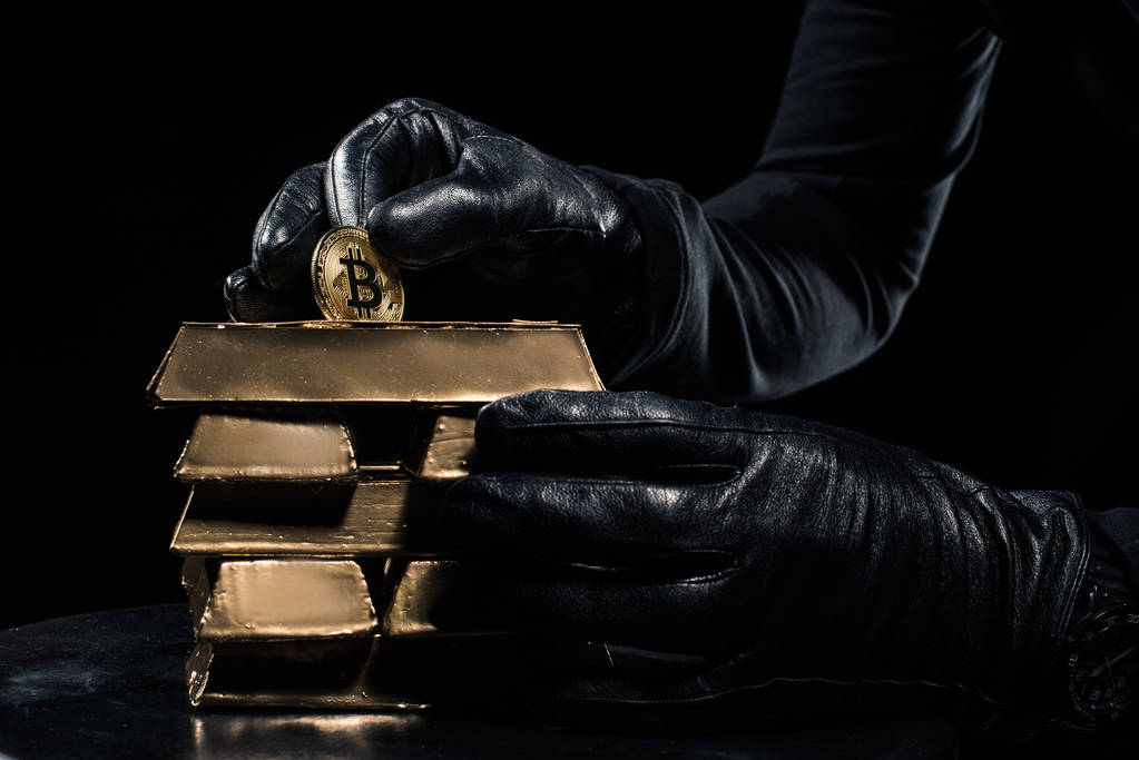 Γκρο πλαν θέα ράβδοι χρυσού και bitcoin στα χέρια του κλέφτη - Φωτογραφία, εικόνα