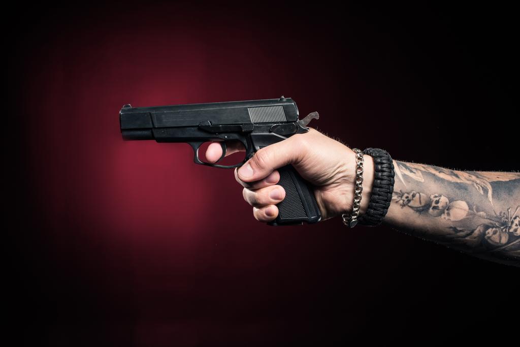 Close-up beeld van mannenhand gericht met pistool - Foto, afbeelding