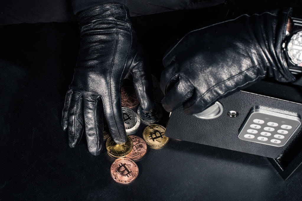 Cropped view of robber stealing bitcoin from safe - Photo, Image