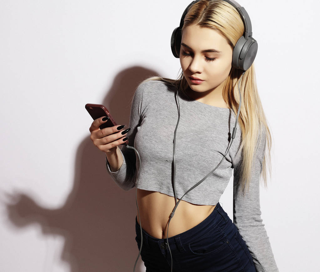 Lifestyle- und People-Konzept: Schöne junge Frau hört Musik über Kopfhörer - Foto, Bild