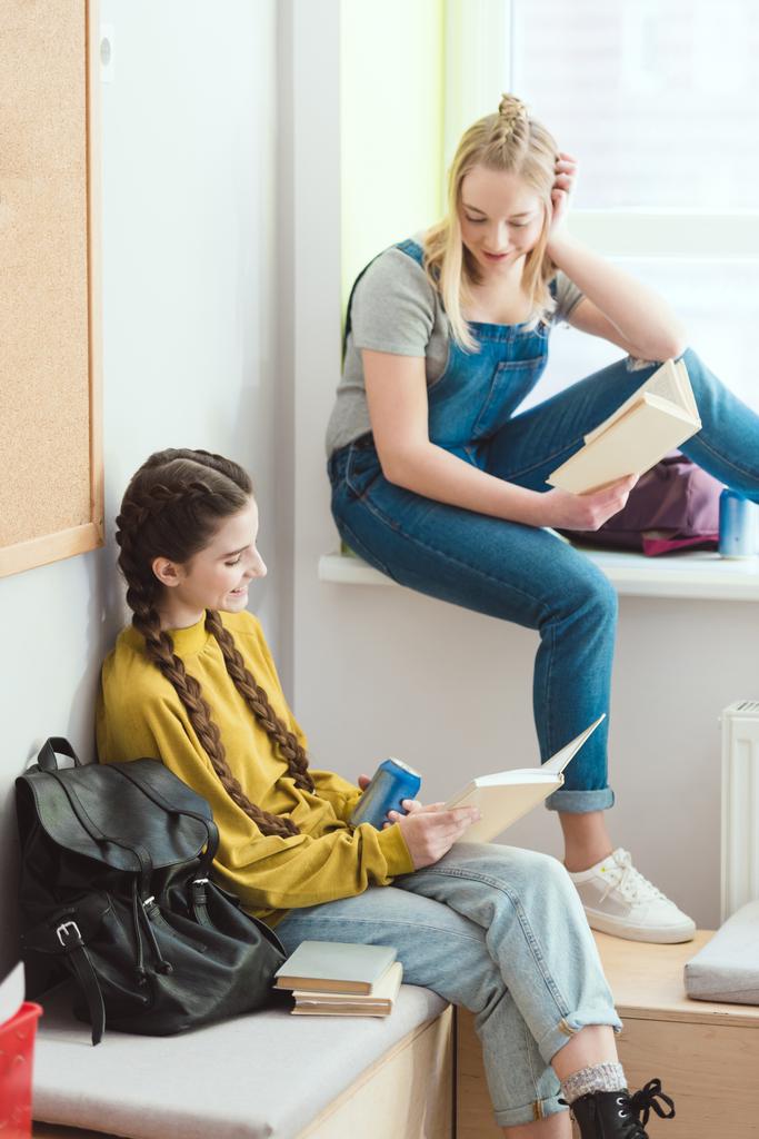 Mosolygó nő középiskolai könyvek beszél egymással - Fotó, kép