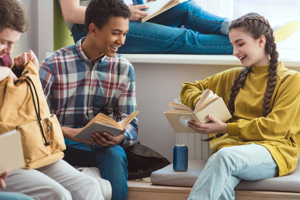 Усміхнені багатоетнічні школярі читають книги під час шкільних канікул
 - Фото, зображення