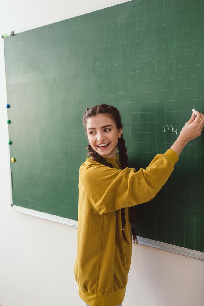 黒板に書く高校女子学生を笑顔 ロイヤリティフリー写真 画像素材