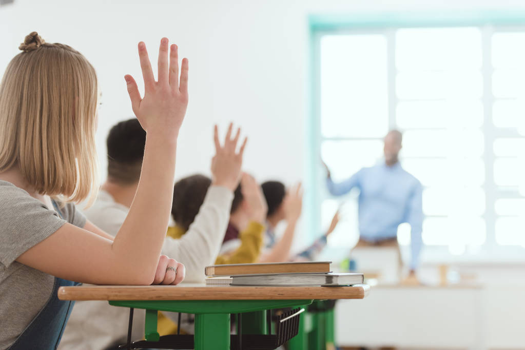 Gymnasiasten heben die Hände, um Lehrerfrage zu beantworten - Foto, Bild