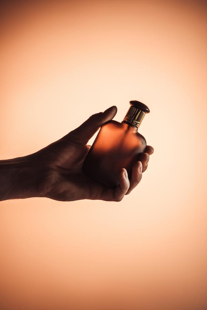 vue recadrée de la main masculine au parfum, isolée sur orange
 - Photo, image