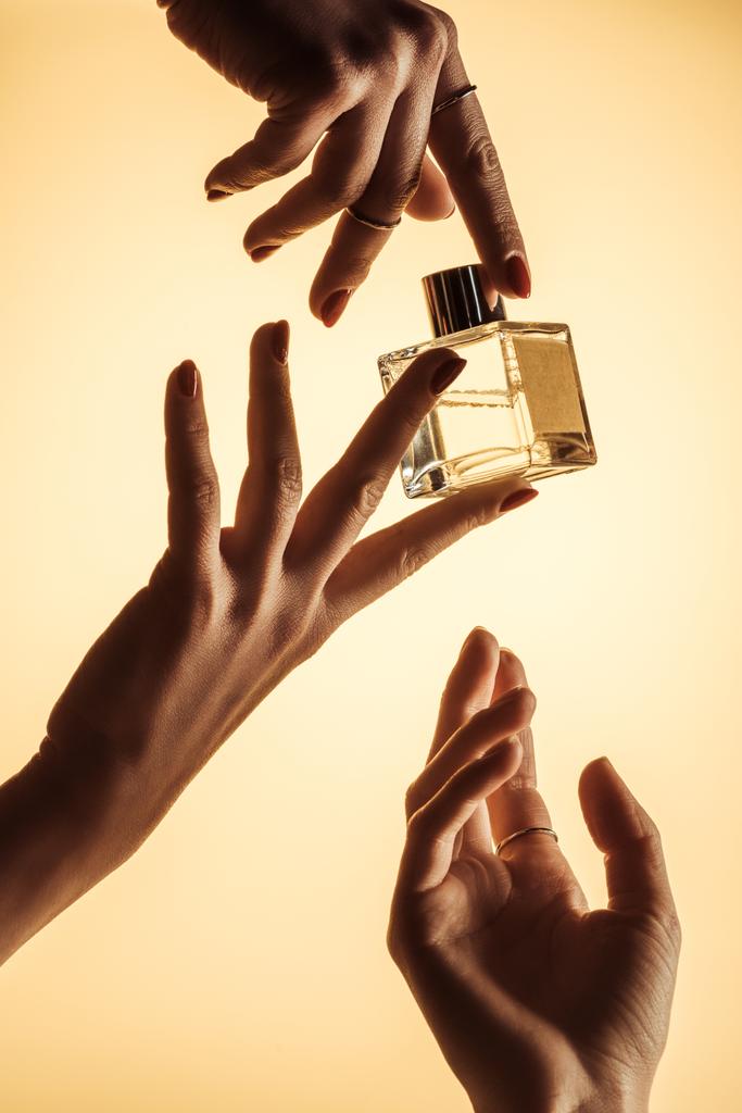 香水、黄色の分離と女性の手のトリミング ビュー - 写真・画像