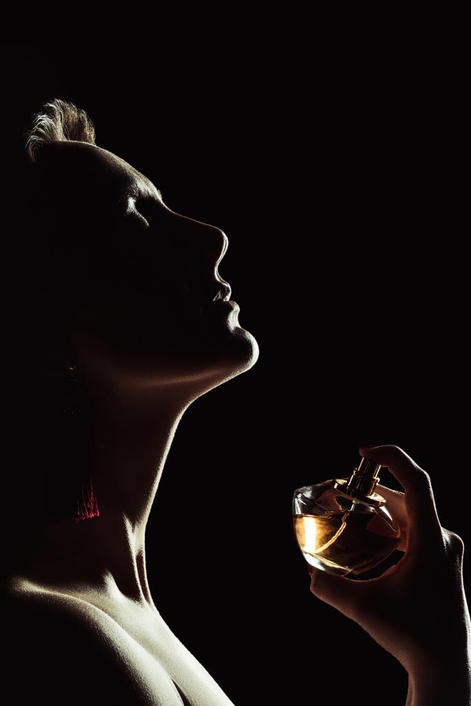 黒に分離された首の香水をスプレーの官能的な女性のシルエット - 写真・画像