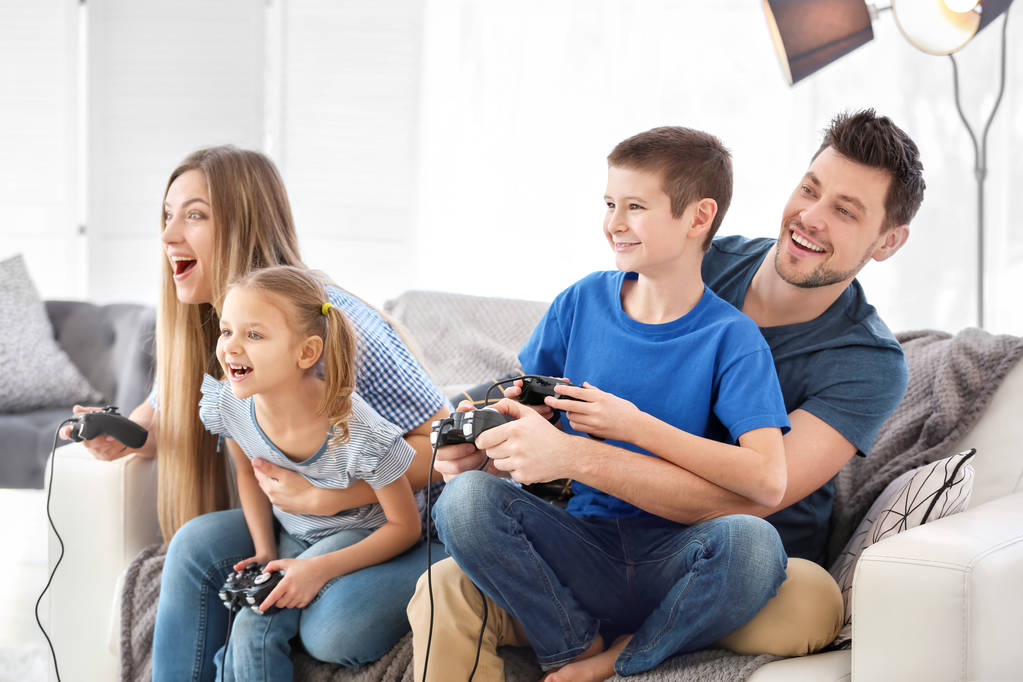 Famille heureuse jouant à des jeux vidéo à la maison
 - Photo, image