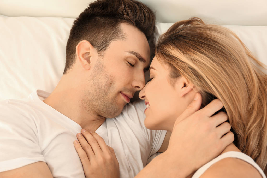 自宅のベッドで眠っている美しい若いカップル - 写真・画像