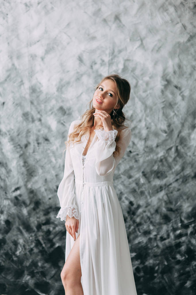 Mooie jonge bruid in boudoir jurk op doek achtergrond met verf. Bruiloft trends en ideeën 2018, lente inspiratie. Bruiloft in de Studio - Foto, afbeelding