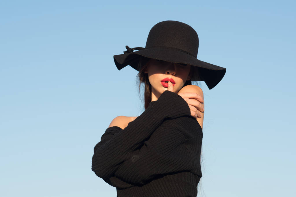 portrait of a young beautiful fashionable woman wearing stylish accessories. Hidden eyes with hat. Female fashion, beauty and advertisement concept. Close up. - Photo, Image