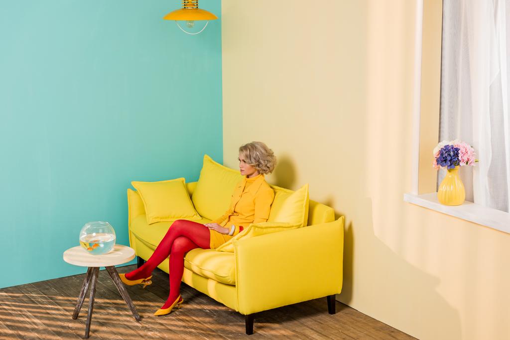 жінка в яскравому ретро одязі відпочиває на дивані в барвистій квартирі, концепція лялькового будинку
 - Фото, зображення