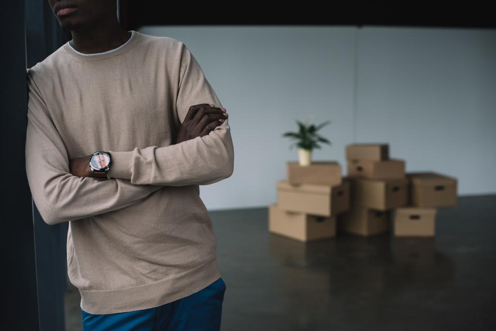 levágott szemcsésedik-ból afrikai amerikai férfi állandó karokkal és karton dobozok mögött az új office - Fotó, kép