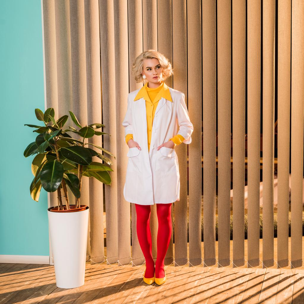 красивий ретро стилізований лікар, що стоїть у білому пальто та червоних колготках у клініці
 - Фото, зображення