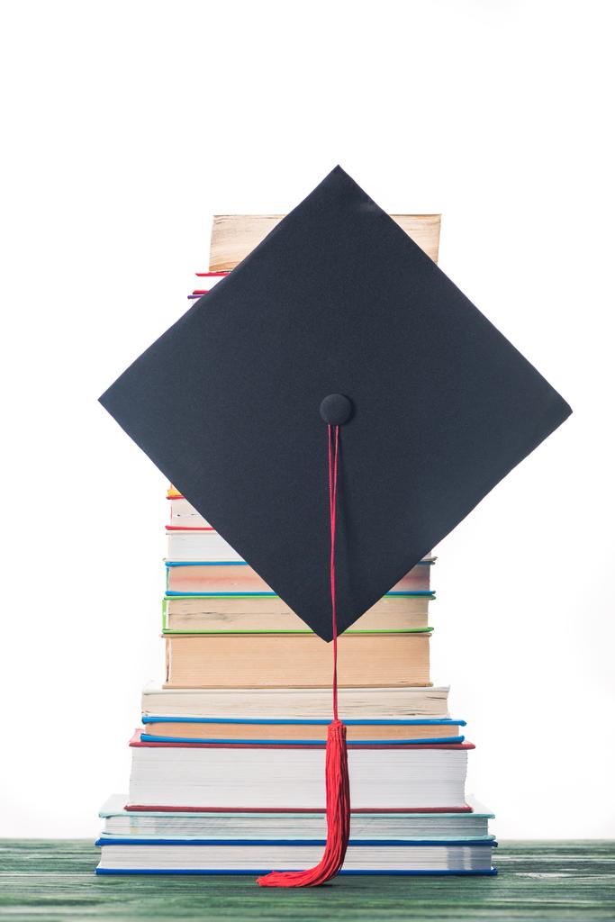 Καπάκι Αποφοίτηση μπροστά από στοίβα βιβλίων - Φωτογραφία, εικόνα