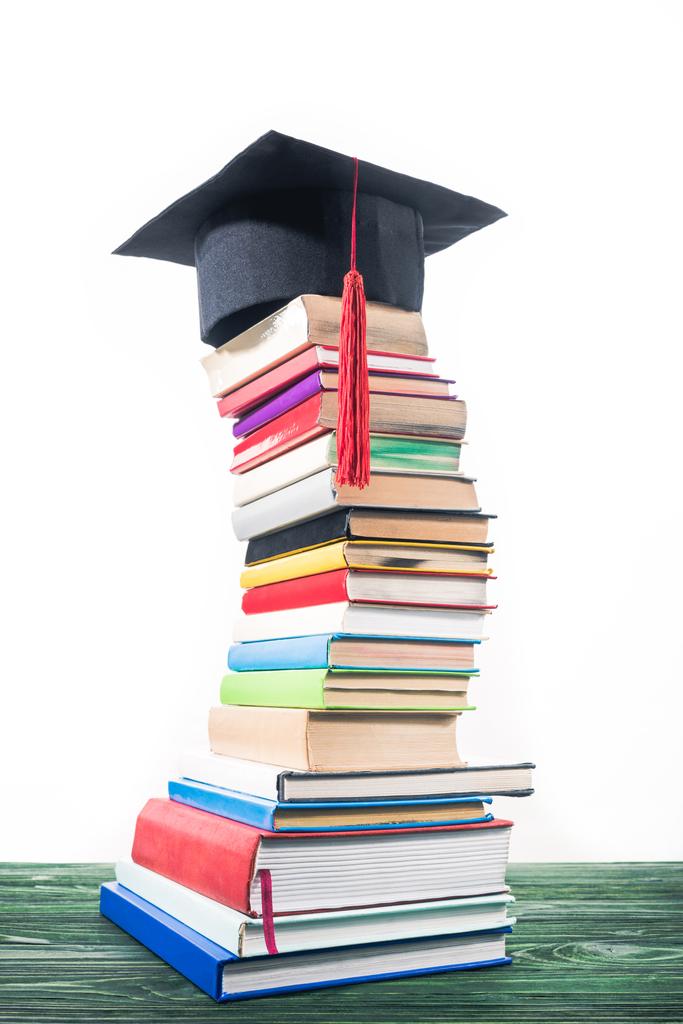 Tapa de graduación en torre doblada de libros apilados
 - Foto, Imagen