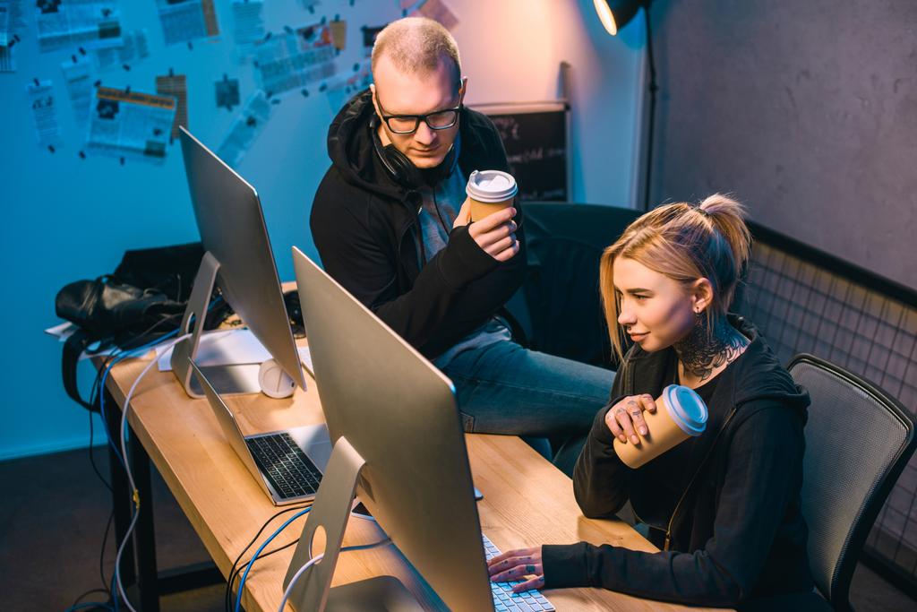 Hackerpaar trinkt Coffee to go und arbeitet im Darkroom an Malware - Foto, Bild