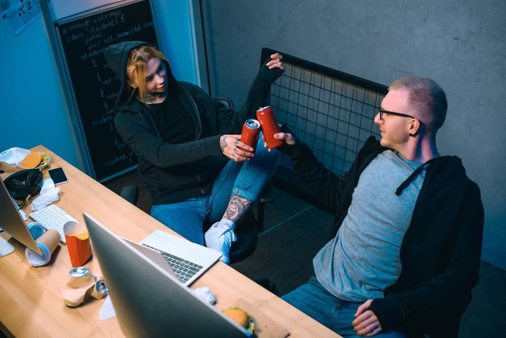 високий кут зору декількох хакерів, які смердять баночки пива на робочому місці
 - Фото, зображення