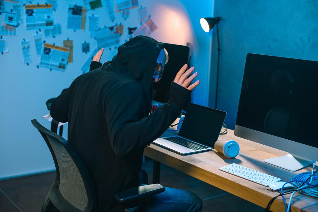 арештований хакер з піднятими руками перед робочим місцем
 - Фото, зображення