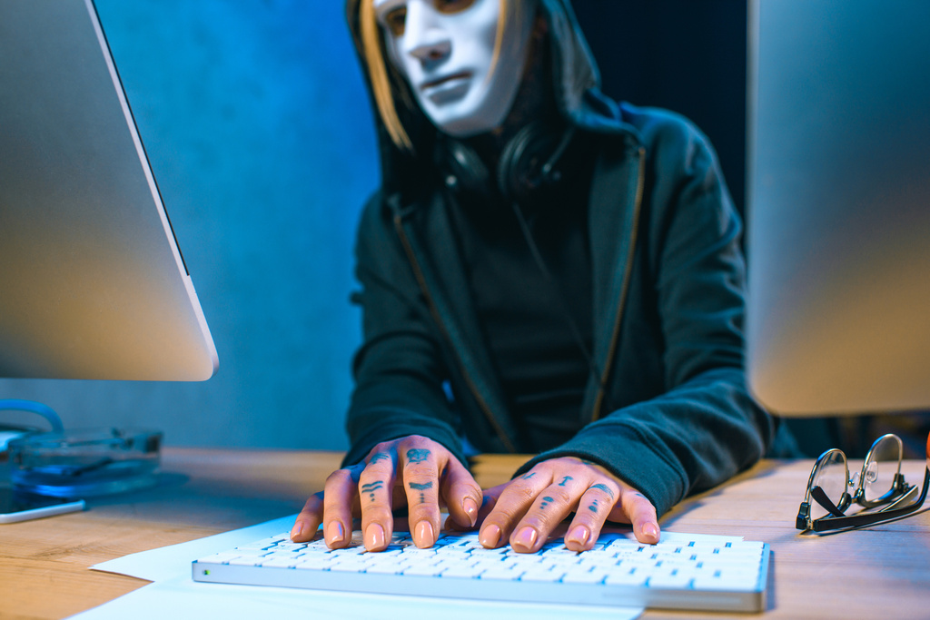 крупним планом знімок маскованого жіночого хакера з татуюваннями на руках розробка шкідливого програмного забезпечення
 - Фото, зображення