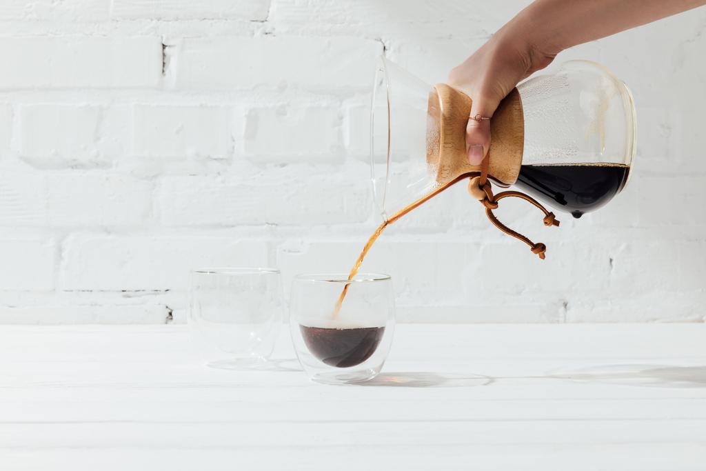 ガラスのマグカップに女性 chemex から注ぐ代替コーヒーのショットをトリミング  - 写真・画像