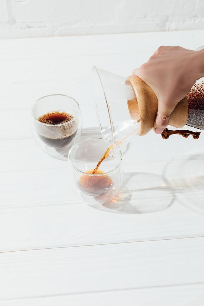 Image recadrée de la femme versant du café alternatif de Chemex dans une tasse en verre
 - Photo, image