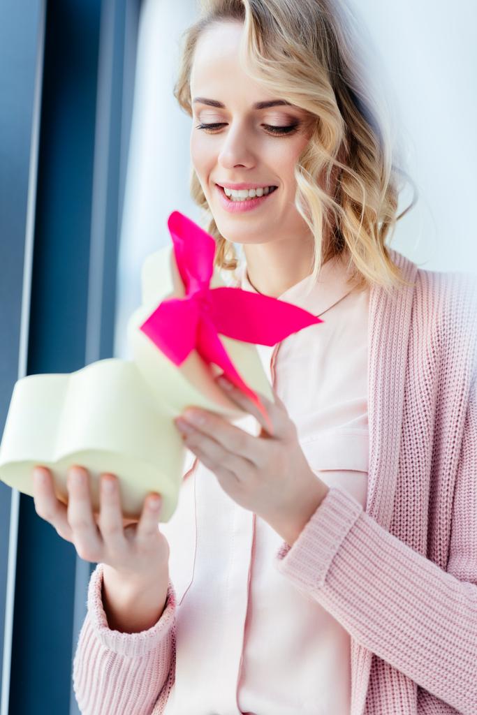 щаслива жінка відкриває подарункову коробку у формі серця в руках, концепція святкового дня матері
 - Фото, зображення