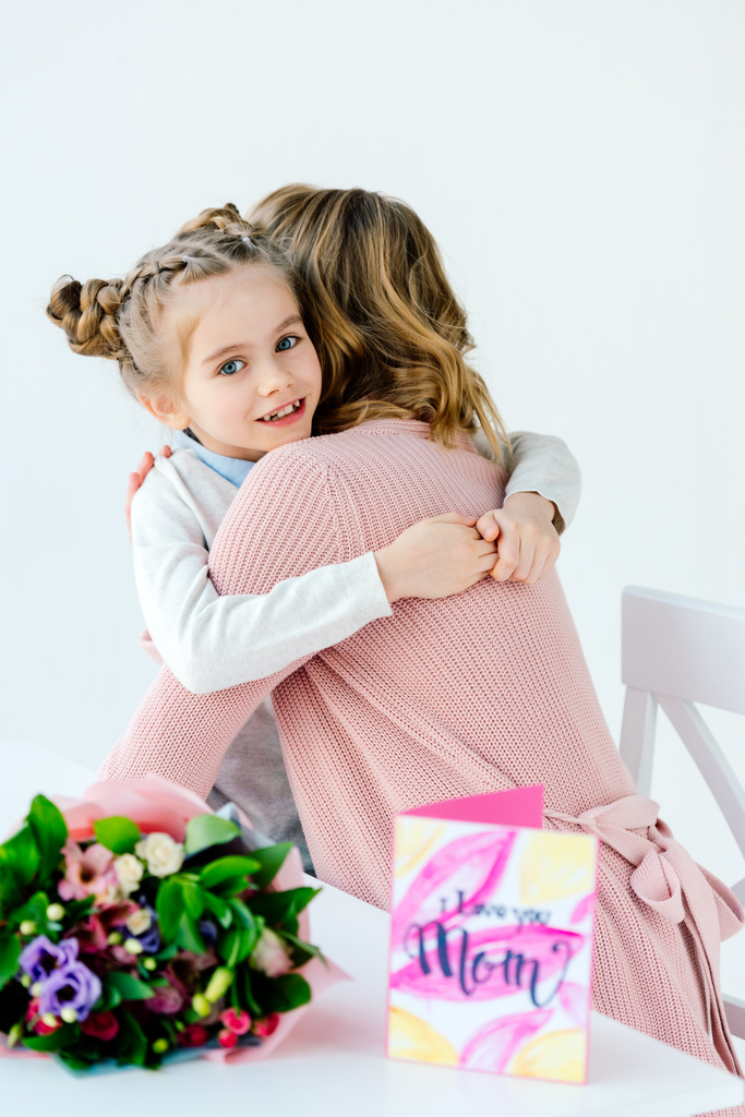 bambino e madre che si abbracciano con regali sul tavolo, concetto di festa delle madri
 - Foto, immagini