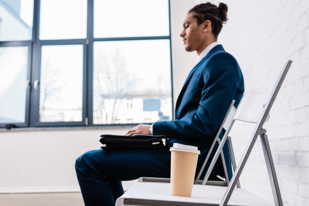 Geschäftsmann sitzt auf Stuhl und wartet bei Kaffeetasse - Foto, Bild